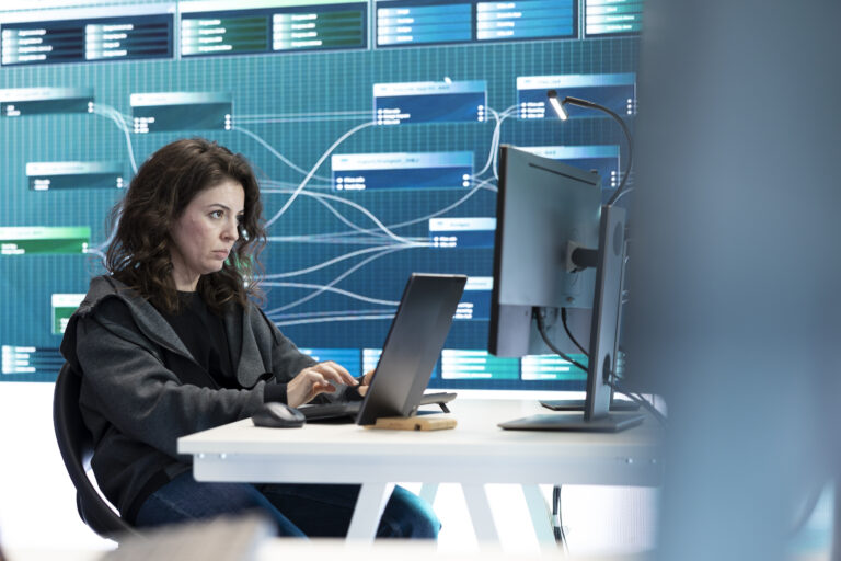 Female governmental hacker examines data on a computer in agency center